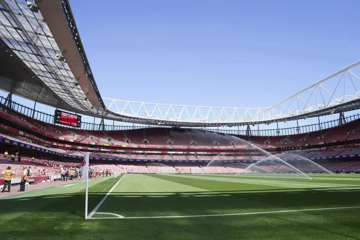 Estadio vacío con césped regado antes del partido
