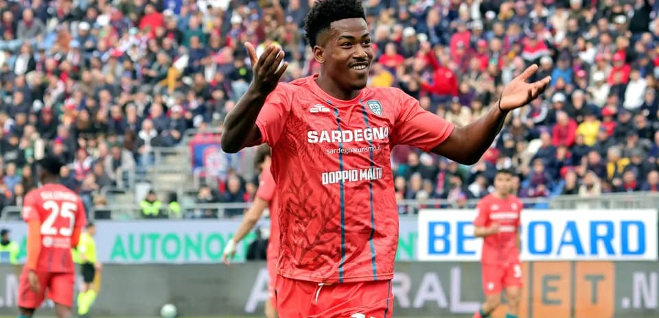 Jugador celebrando en partido de fútbol con público