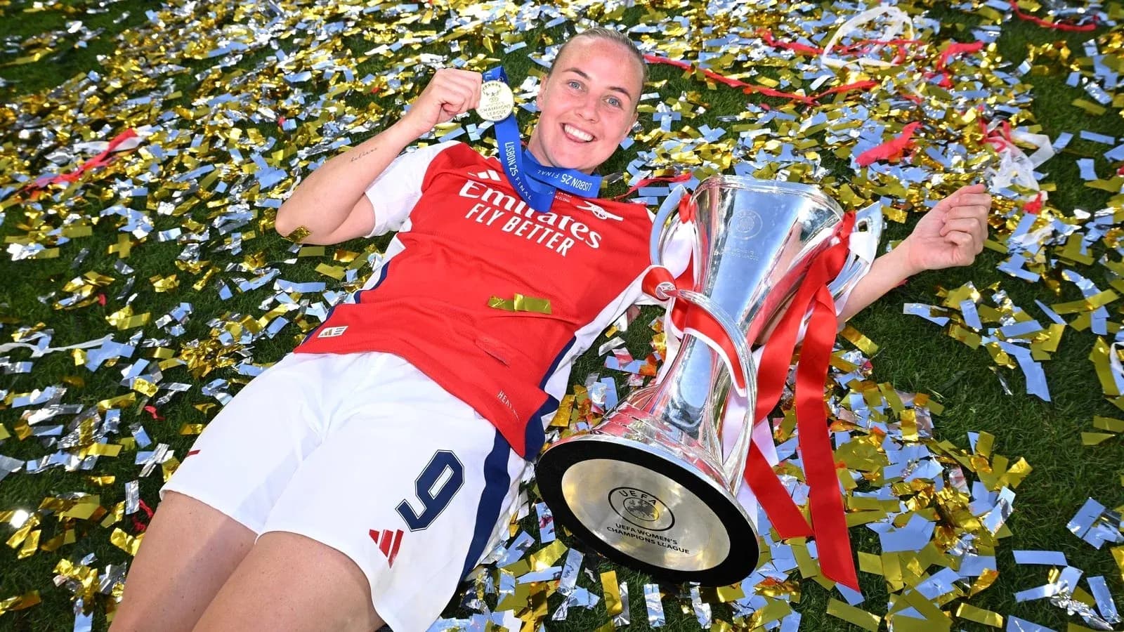 Jugadora de Arsenal celebrando con trofeo y medalla