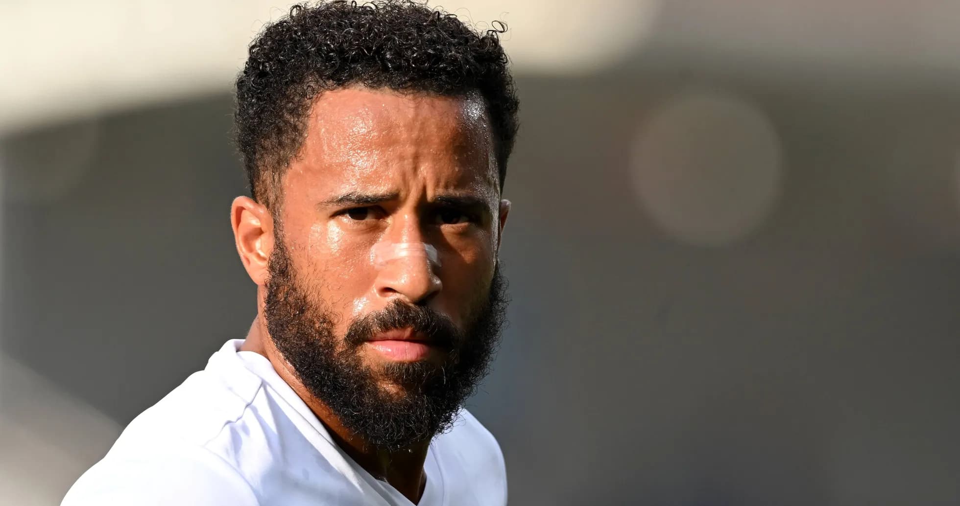 Jugador de fútbol con barba y camiseta blanca