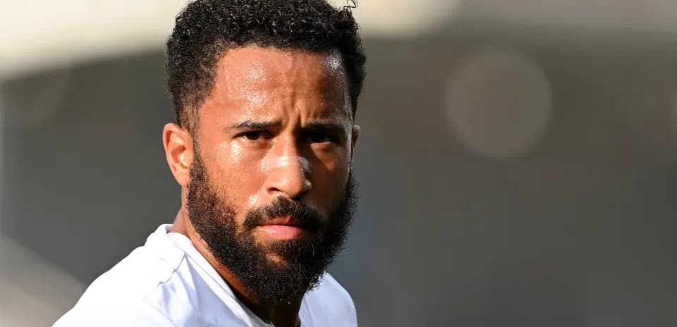 Jugador de fútbol con barba y camiseta blanca