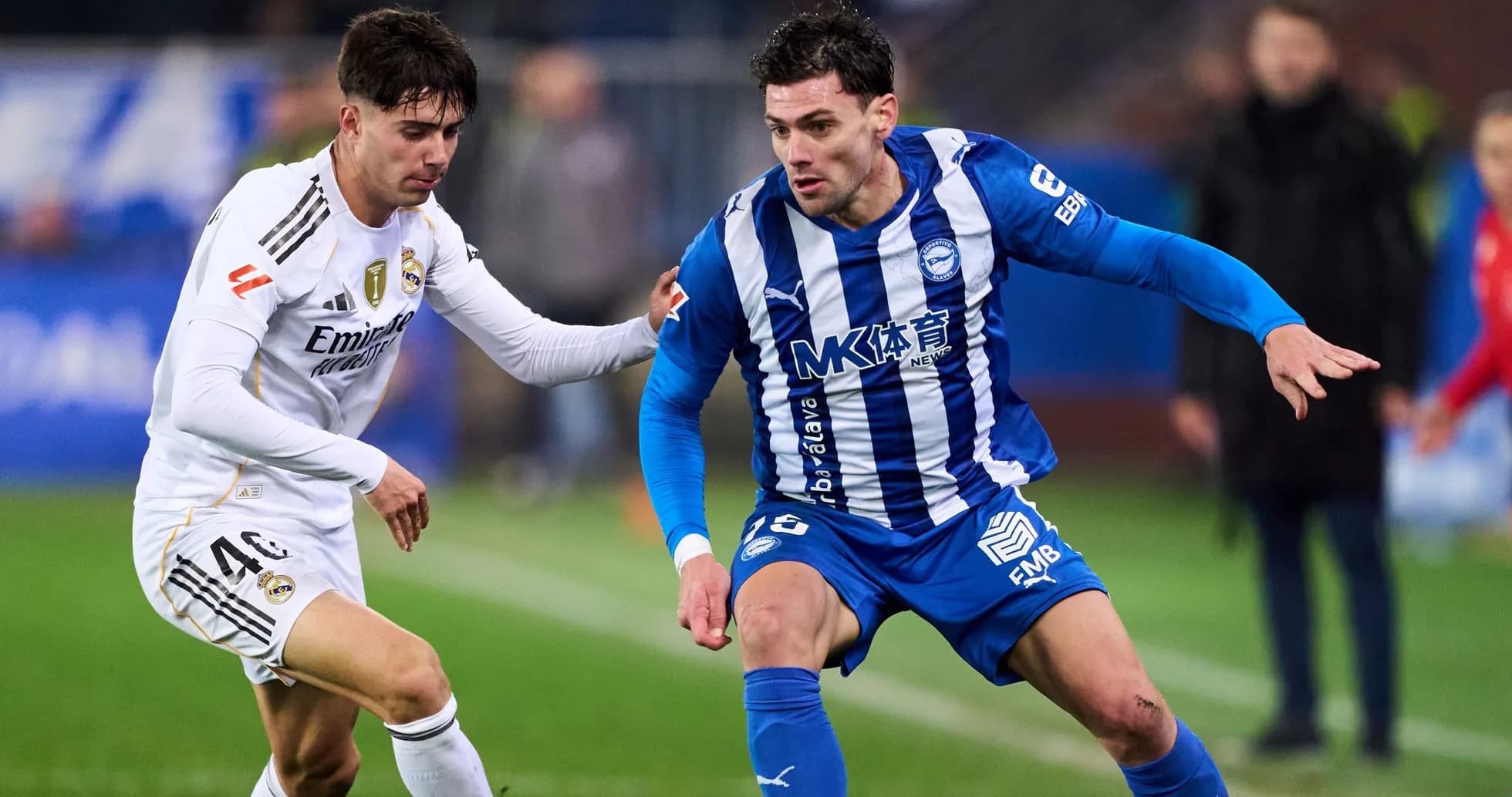 Dos jugadores compitiendo por el balón en el campo