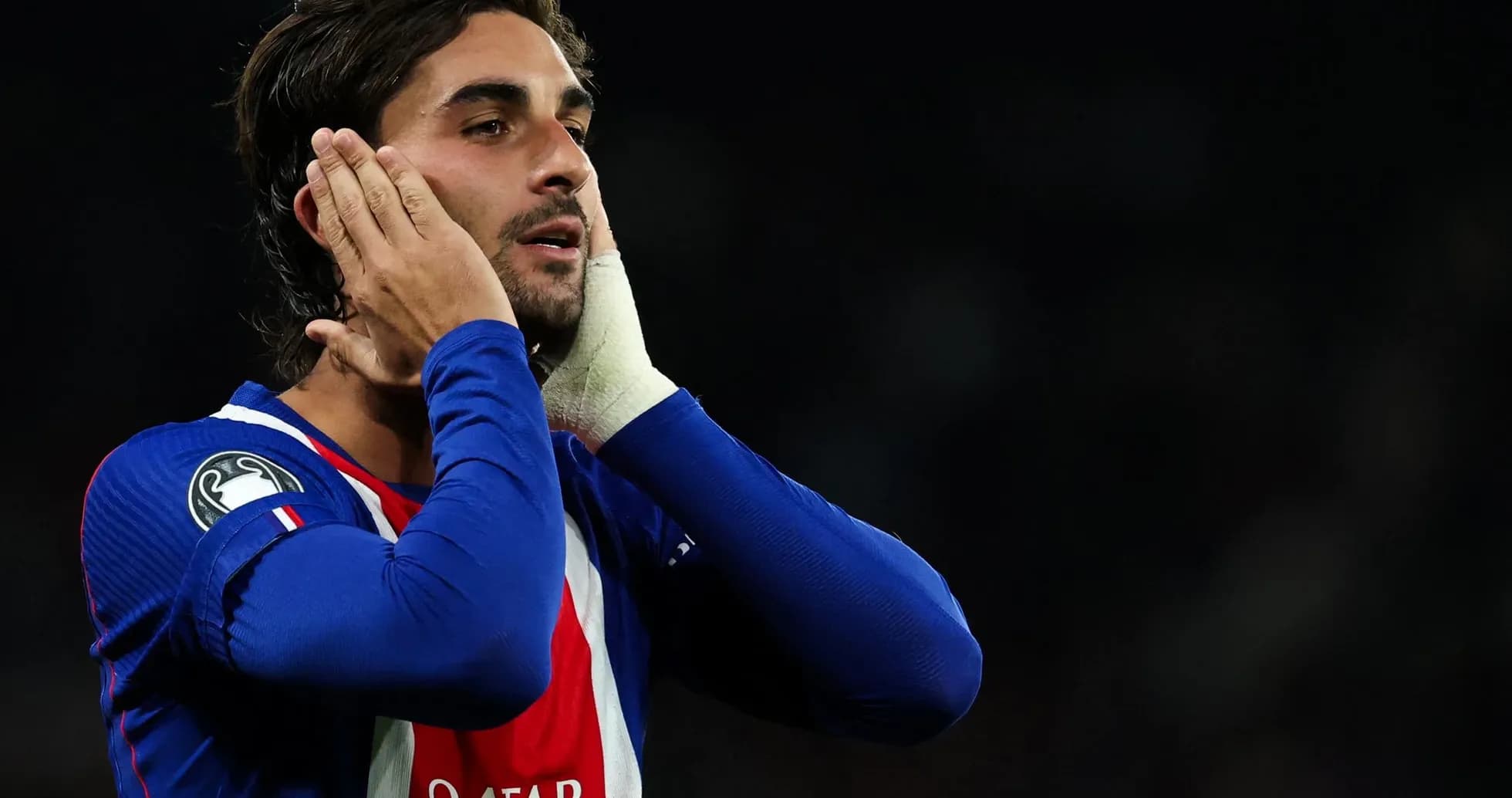 Jugador con camiseta azul tocándose la cara