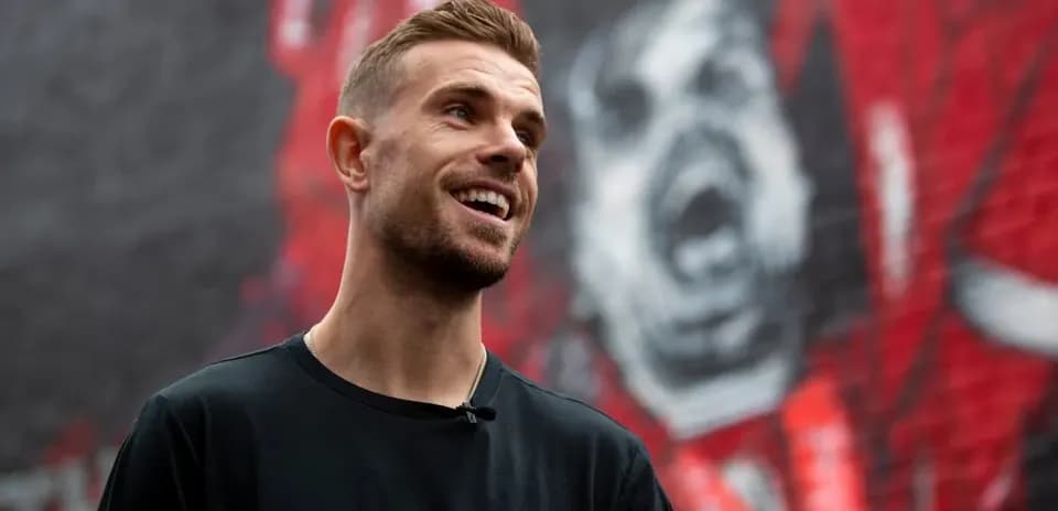 Jugador sonriendo frente a un mural de arte urbano