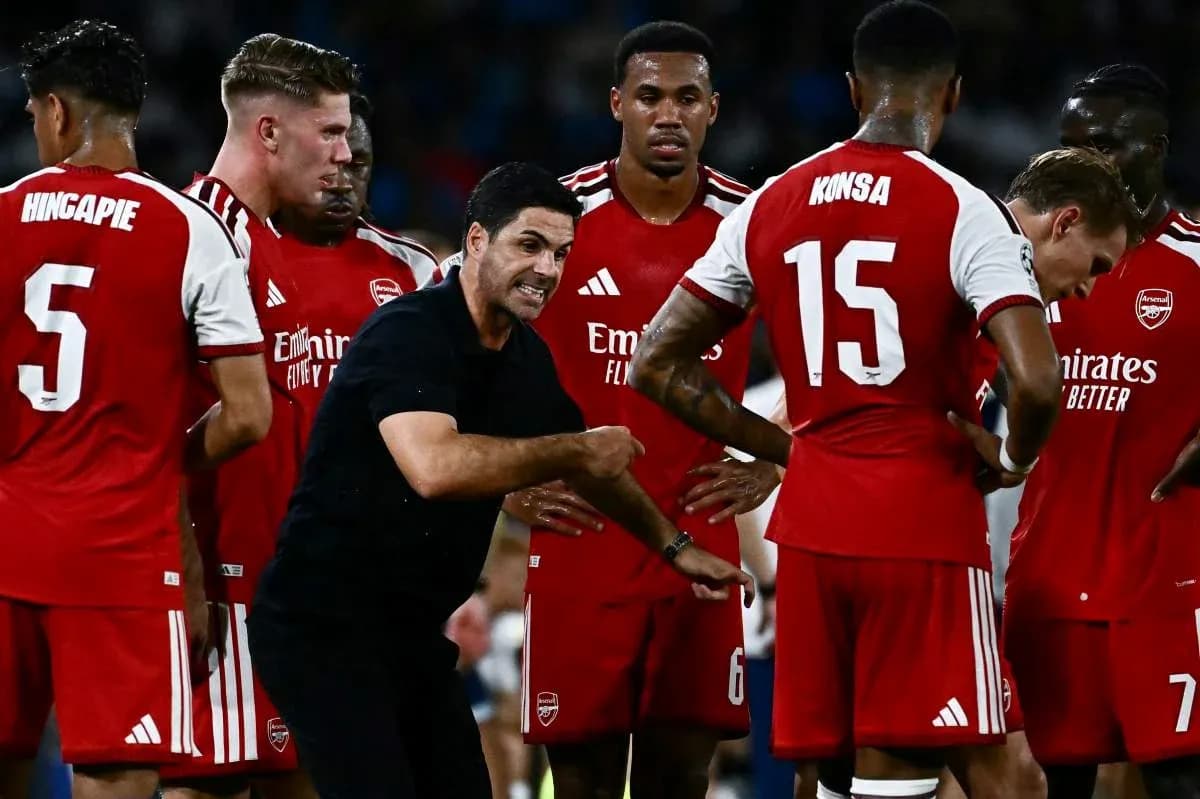 Entrenador instruyendo a jugadores de Arsenal durante reunión