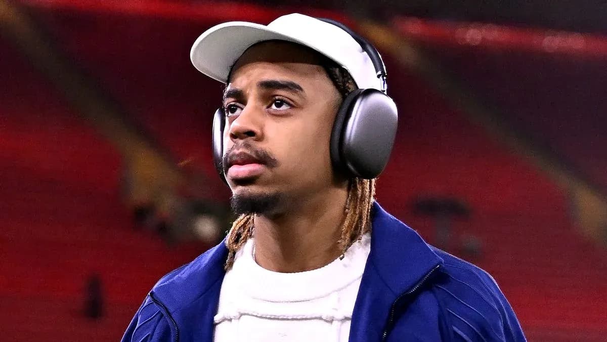 Jugador caminando con auriculares en estadio