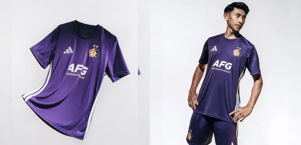 Jugador con uniforme morado de fútbol posando
