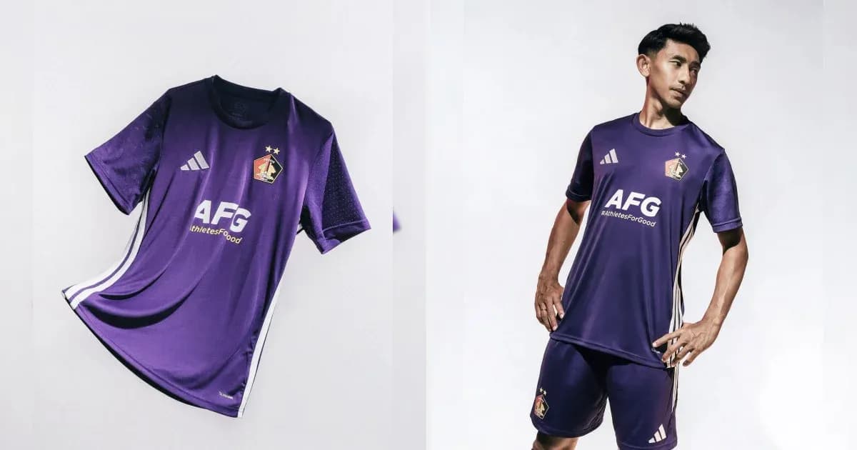 Jugador con uniforme morado de fútbol posando