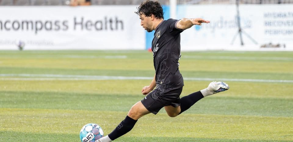 Jugador pateando el balón en el campo