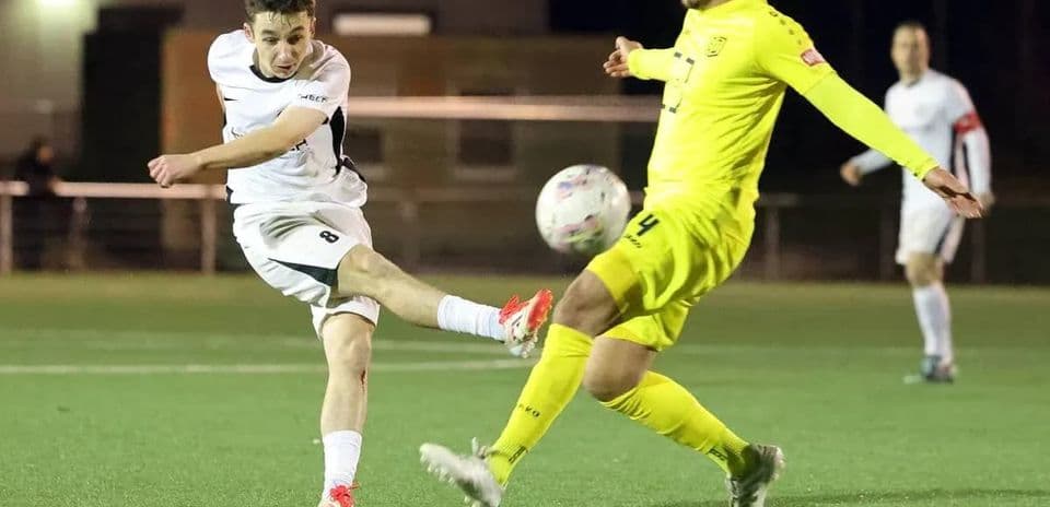 Jugador disparando a portería en partido de fútbol