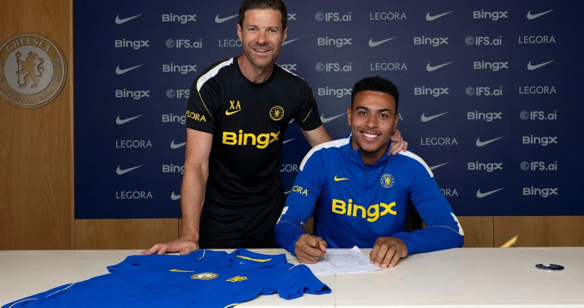 Jugador firmando contrato con entrenador en conferencia