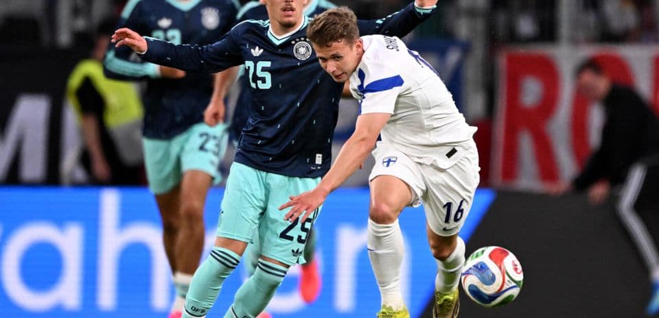 Jugador de Finlandia despojando el balón a rival alemán
