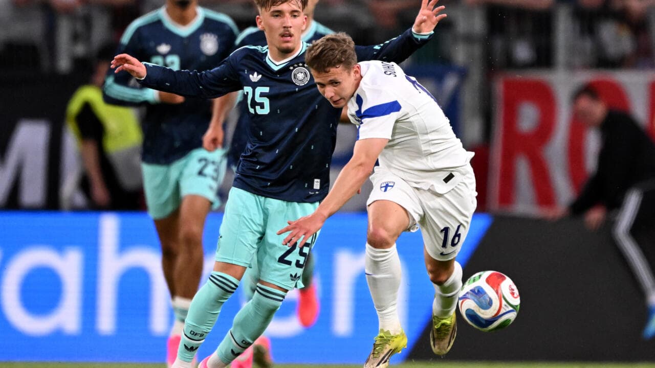 Jugador de Finlandia despojando el balón a rival alemán