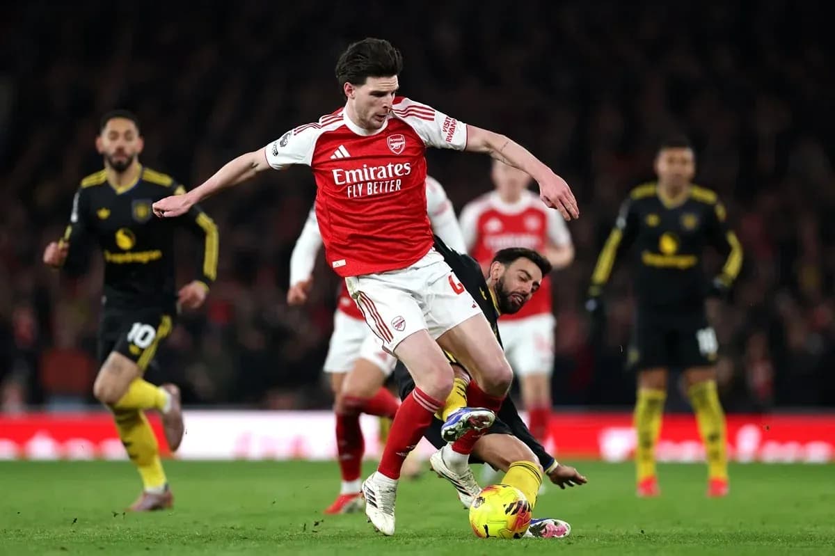 Jugador de Arsenal superando a rival en el suelo