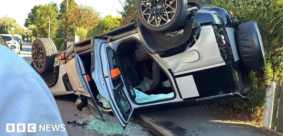 Coche volcado en la calle con vidrios rotos