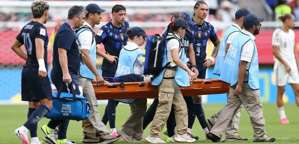 Jugadores y personal médico transportando una camilla