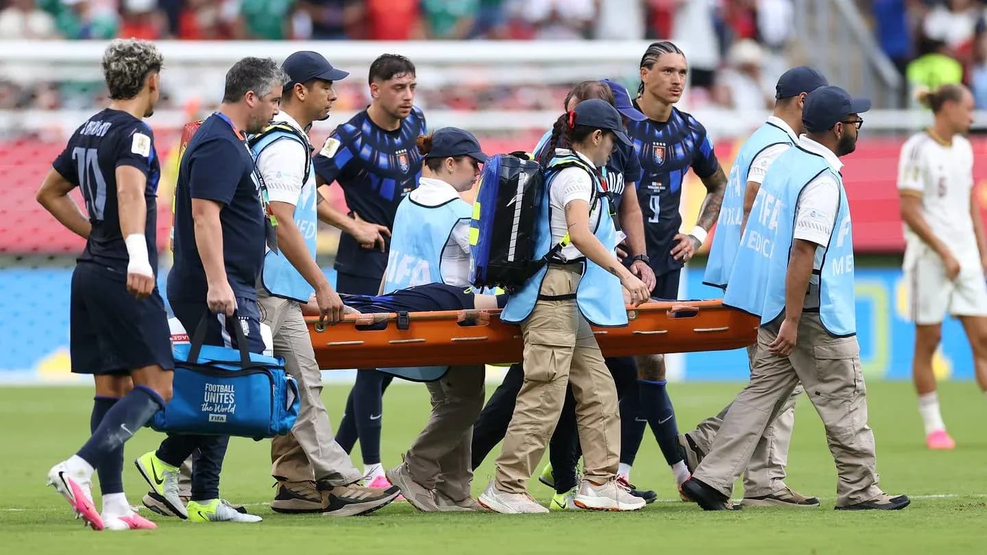 Jugadores y personal médico transportando una camilla