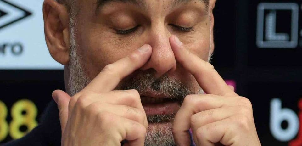 Entrenador gesticulando durante una conferencia de prensa
