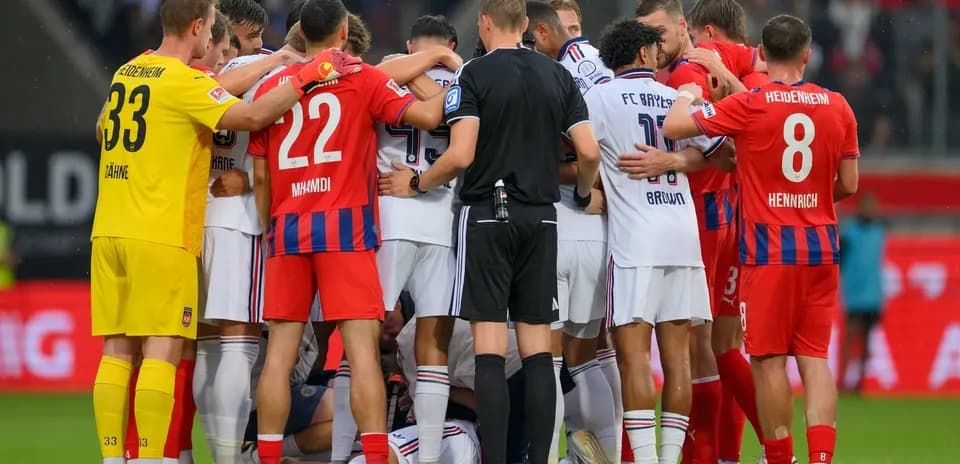 Jugadores y árbitro en un círculo durante el partido