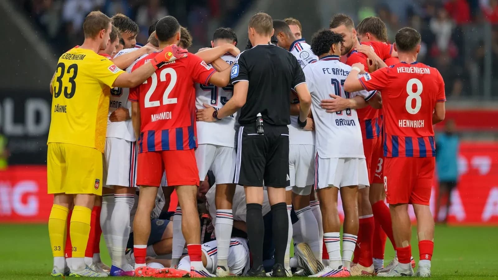 Jugadores y árbitro en un círculo durante el partido
