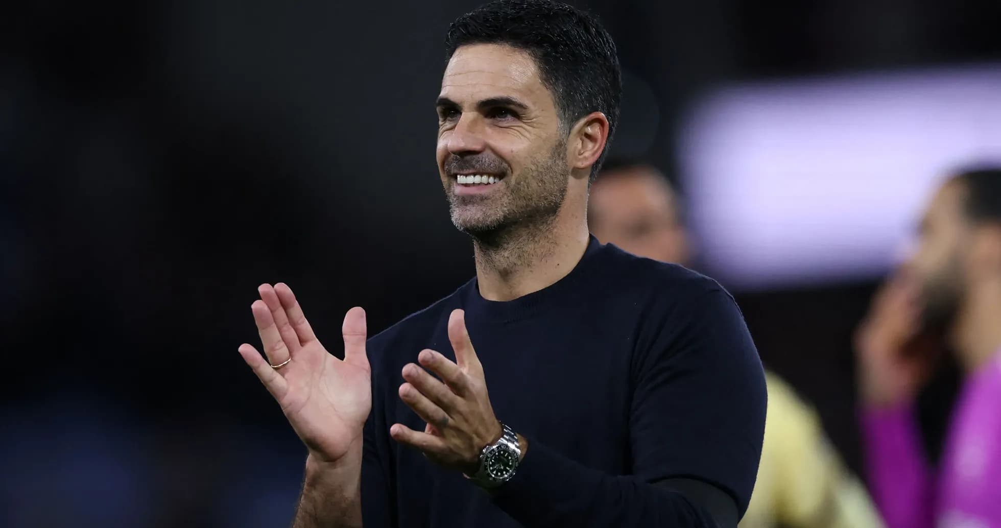 Entrenador aplaudiendo en el banquillo durante el partido