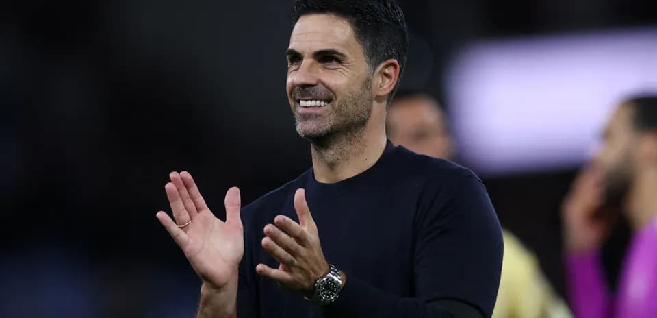Entrenador aplaudiendo en el banquillo durante el partido