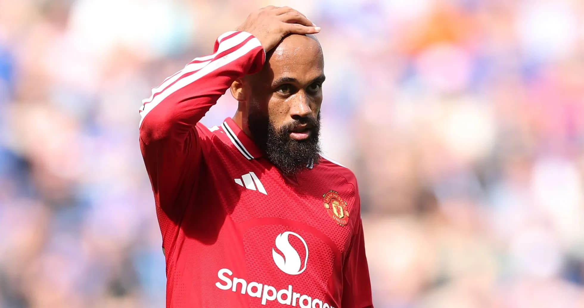 Jugador de Manchester United tocándose la cabeza en el campo