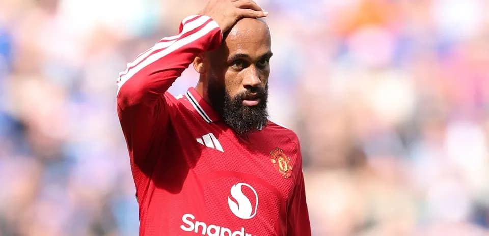 Jugador de Manchester United tocándose la cabeza en el campo