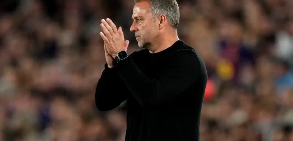 Entrenador aplaudiendo en el banquillo durante el partido
