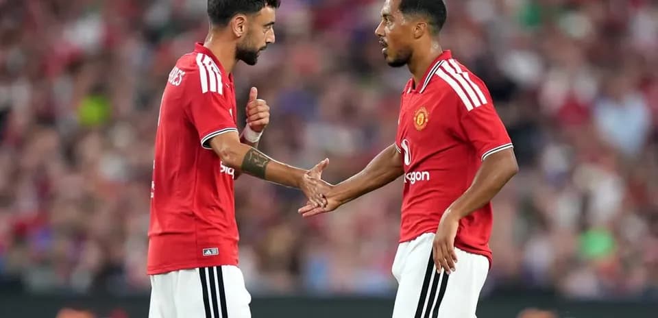 Jugadores de Manchester United intercambiando gestos en el campo