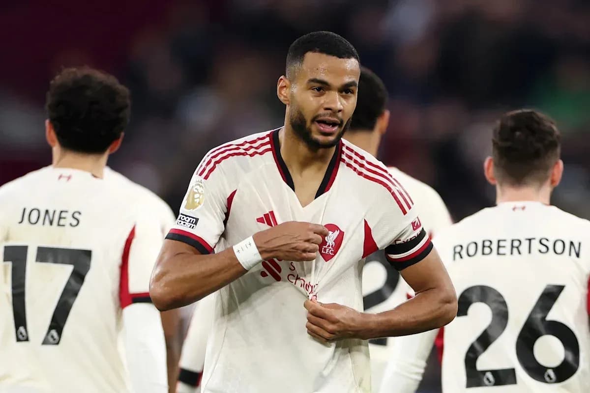 Jugador de Liverpool señalando su camiseta en el campo