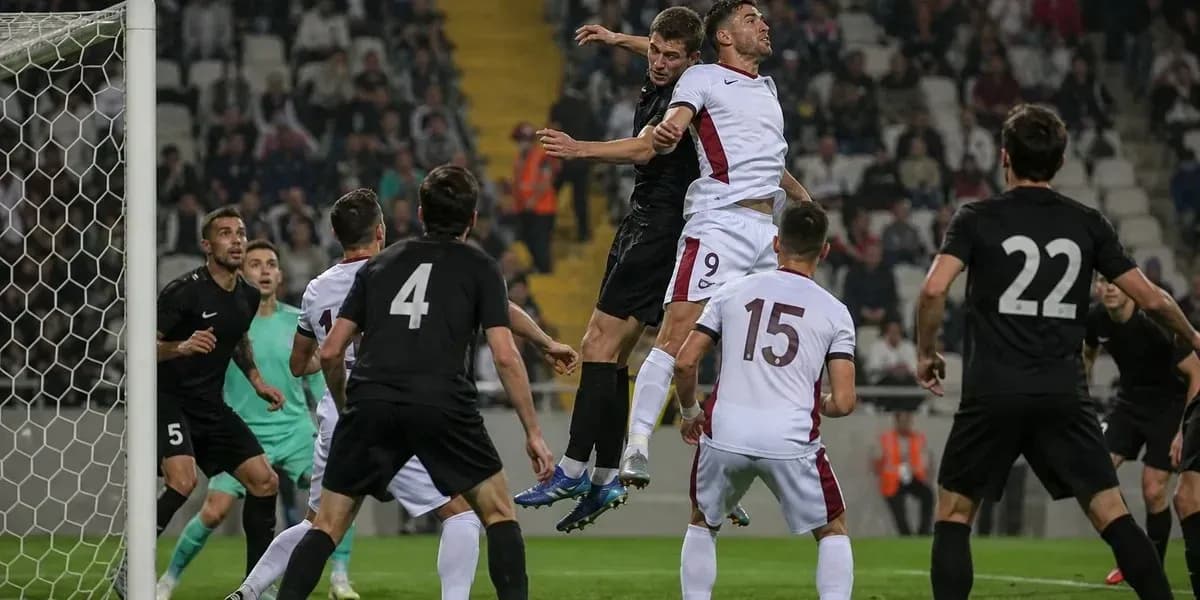 Jugadores saltando por el balón en el área de gol