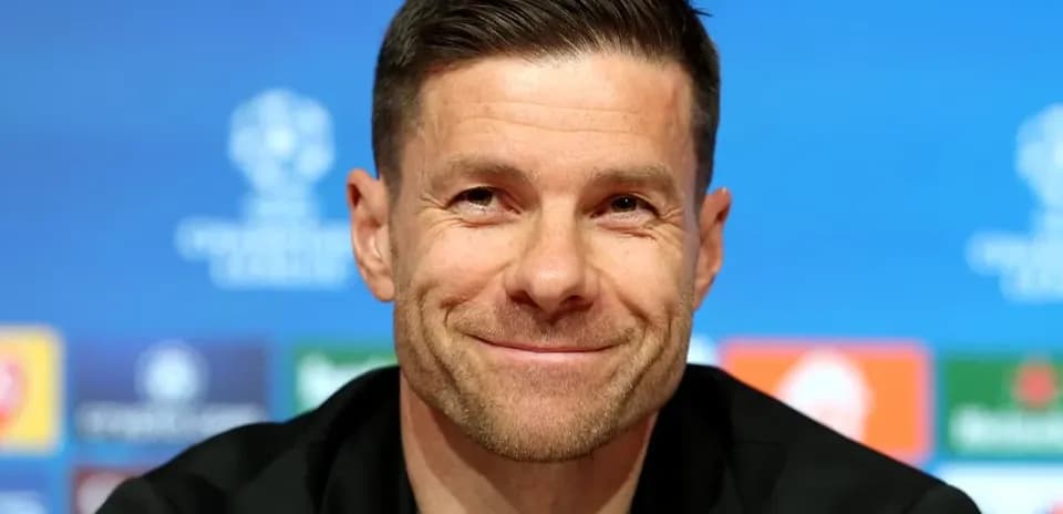 Entrenador en conferencia de prensa sonriendo