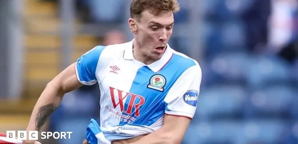Jugador de Blackburn Rovers ajustando su camiseta durante el partido