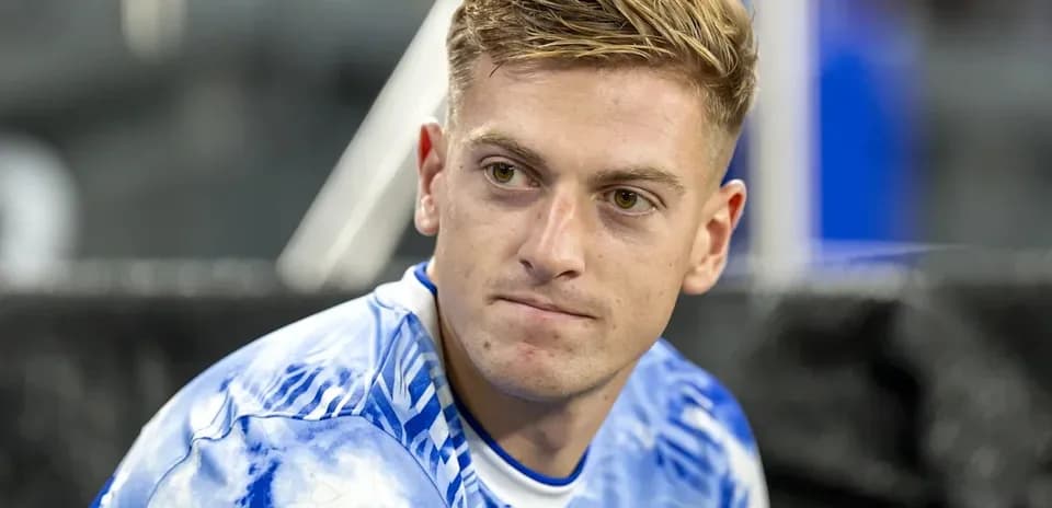 Jugador sentado con camiseta azul durante el partido