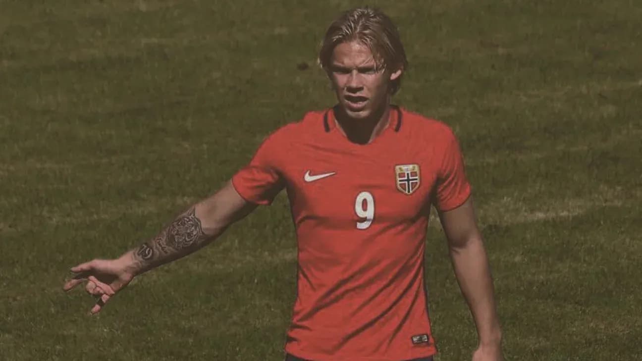 Jugador noruego en camiseta roja señalando durante partido