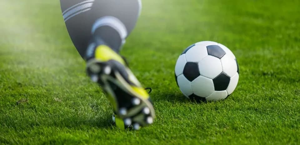 Jugador pateando un balón de fútbol en el campo