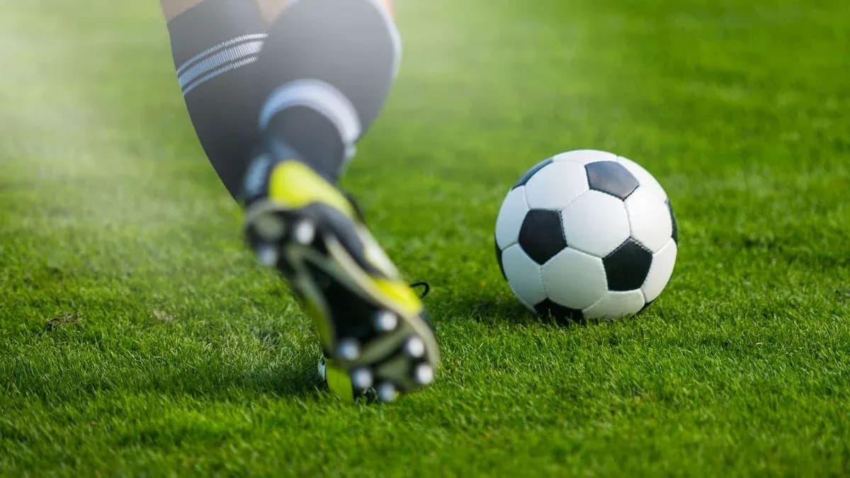 Jugador pateando un balón de fútbol en el campo