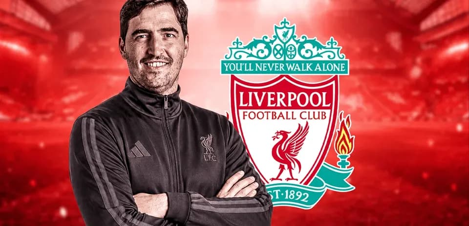 Entrenador posando con escudo del Liverpool FC