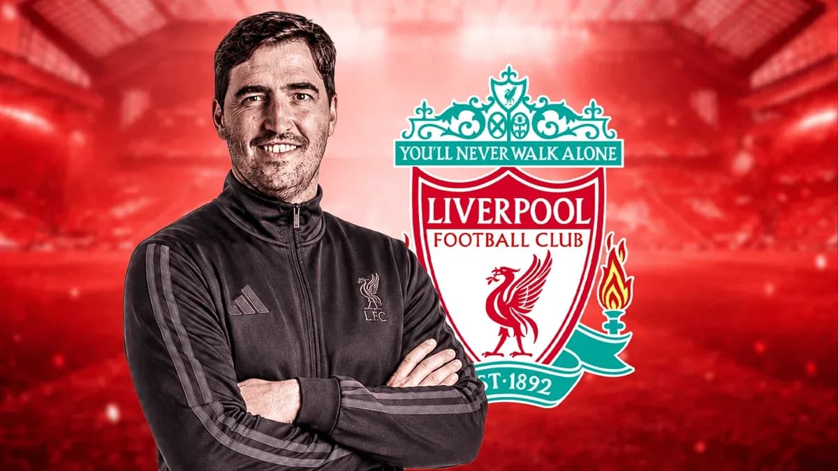 Entrenador posando con escudo del Liverpool FC