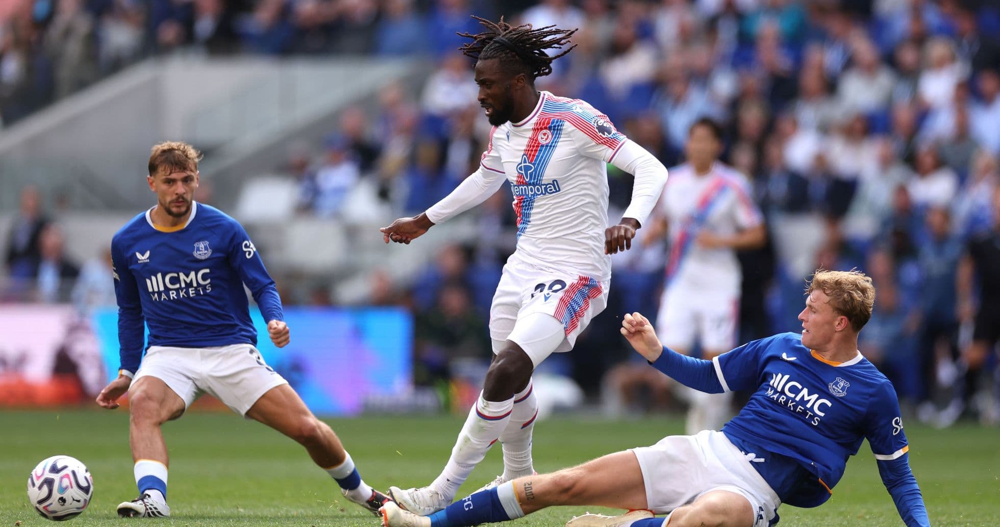 Jugador de Crystal Palace esquivando a dos rivales de Everton
