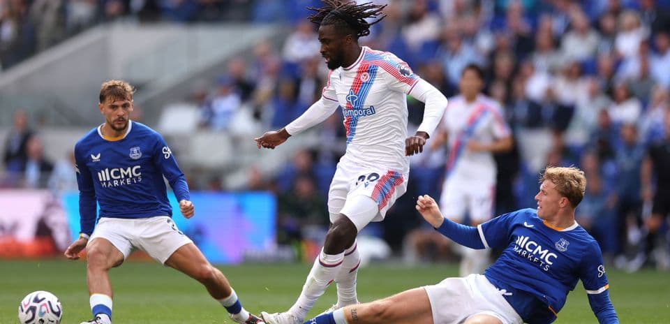 Jugador de Crystal Palace esquivando a dos rivales de Everton