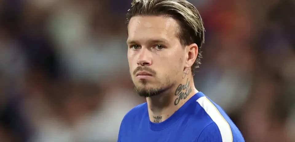 Jugador con camiseta azul en el campo de fútbol