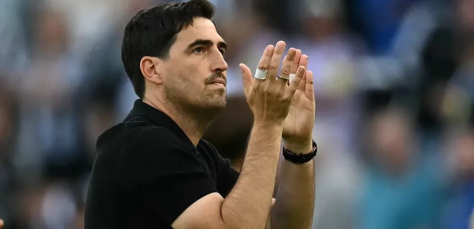 Entrenador aplaudiendo a la afición en el estadio