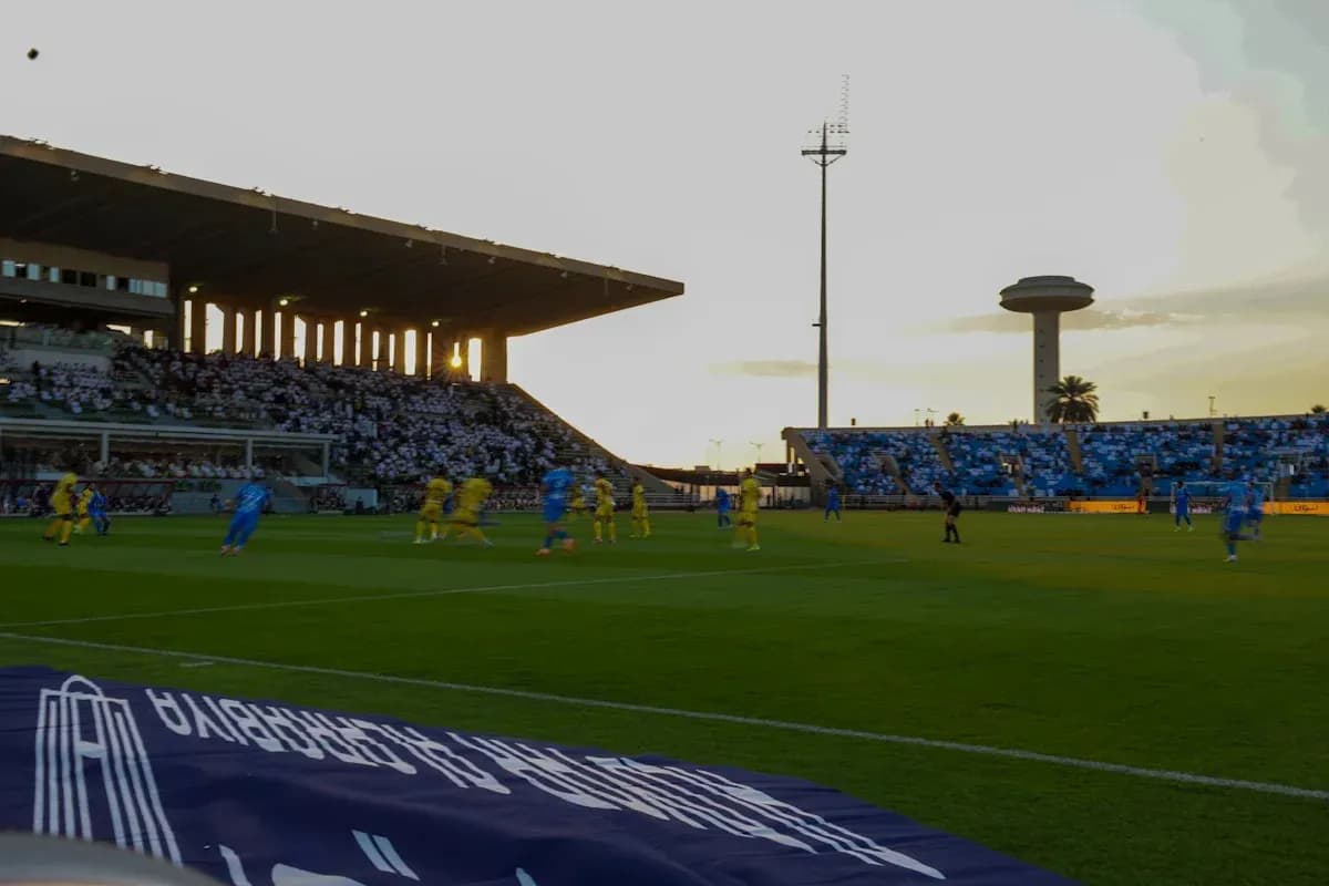Partido de fútbol en estadio con espectadores