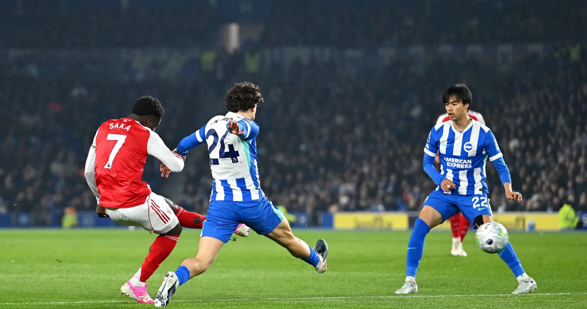 Saka disparando mientras dos defensores de Brighton intentan bloquear