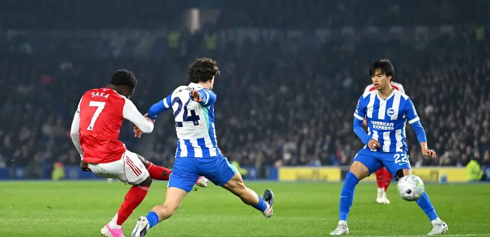 Saka disparando mientras dos defensores de Brighton intentan bloquear