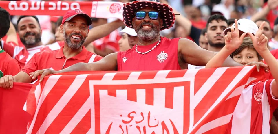 Aficionados de Wydad Casablanca celebrando con bandera