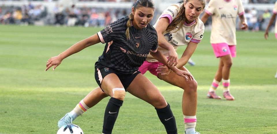 Dos jugadoras compitiendo por el balón en fútbol