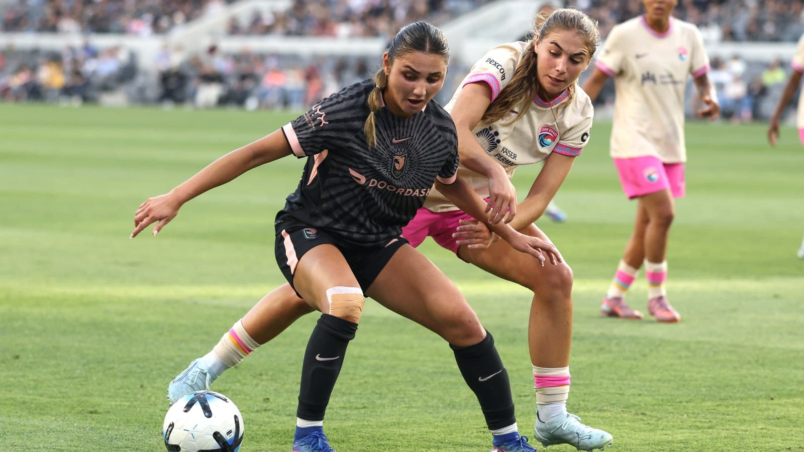 Dos jugadoras compitiendo por el balón en fútbol